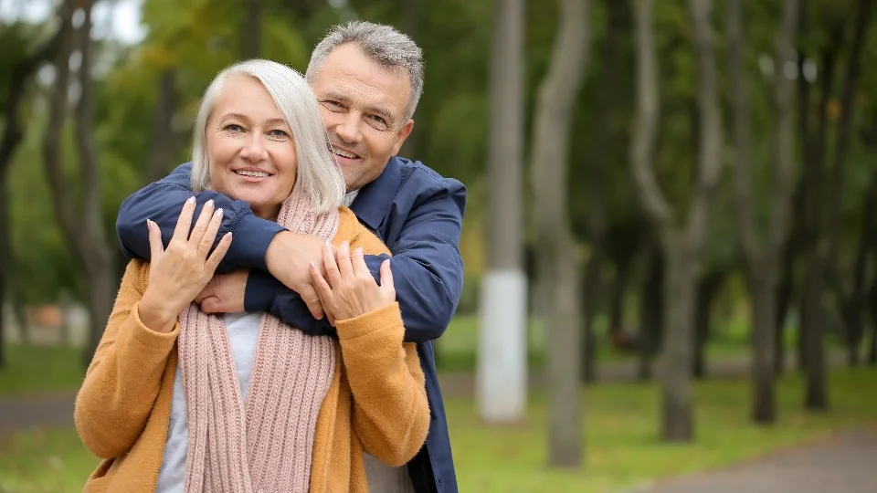 Older couple laughing together during a walk in the park
